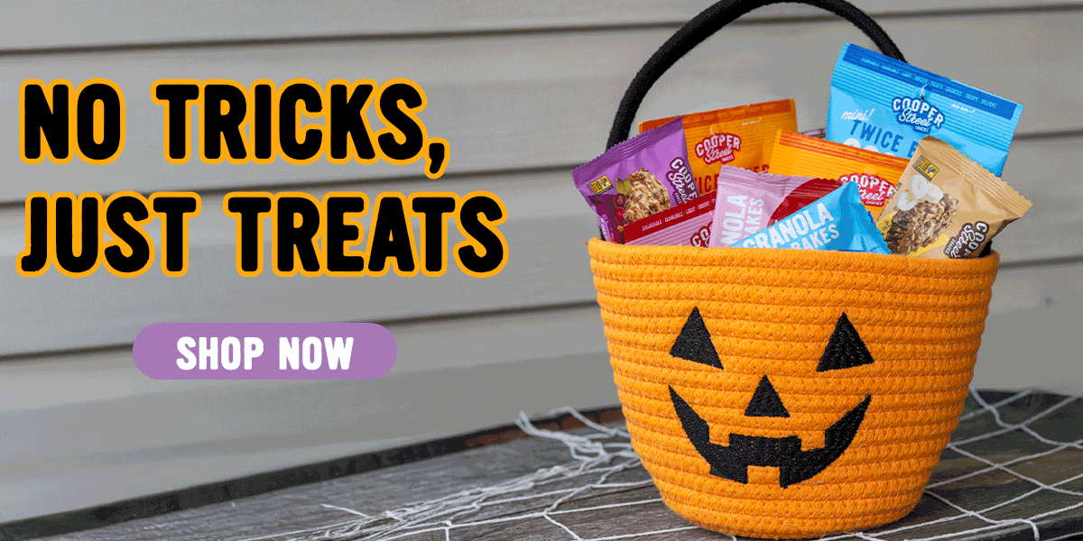 Halloween-themed basket with Cooper Street Tice Based Cookies and Granola Bakes. 'No Tricks, Just Treats' text with a 'Shop Now' button